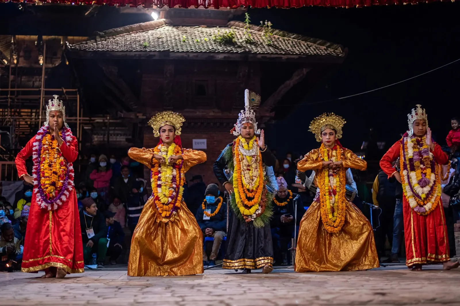 A line of crowned dancers in front of the temple